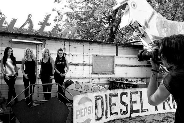 BTS photo band photography four members of female music group The Mrs standing against old building with Austin sign above it