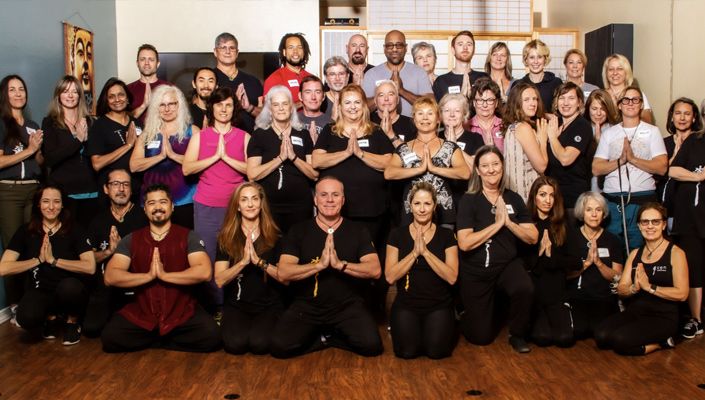 Team branding portrait Zen Wellness staff all with hands clasped together in front of chest