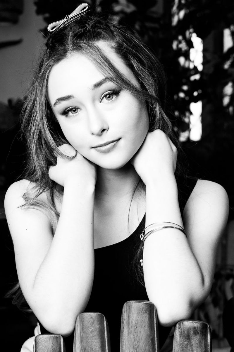 Black and white personal branding portrait Frankie Jensen sitting resting face on hands