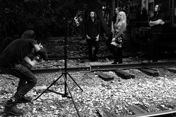 Behind the scenes Nashville Tennesse photoshoot Mark Maryanovich photographing Juliana Hale And Band of Roses standing against boxcar