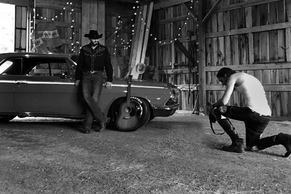 Country Music Photography behind the scenes Mark Maryanovich kneeling while looking at back of camera Chance Moore standing next to old car