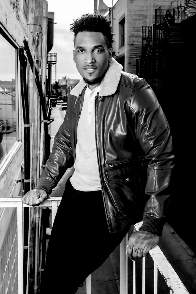 Joe Barksdale black and white personal branding photo leaning against balcony railing smiling