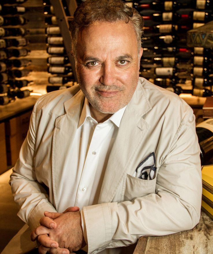 Executive Portrait Ardie Tavangarian sitting in front of wine bottles in wine cellar