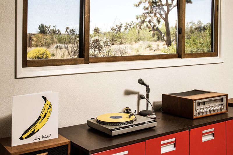 Place branding image Gatos Trail records turn table beneath window looking out on Joshua Tree in desert