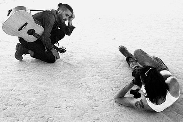 Black and white behind the scenes photo high angle perspective Mark Maryanovich lying down photographing musician Michael Bernard Fitzgerald