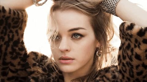 Portrait of a young woman wearing animal print against a soft background.