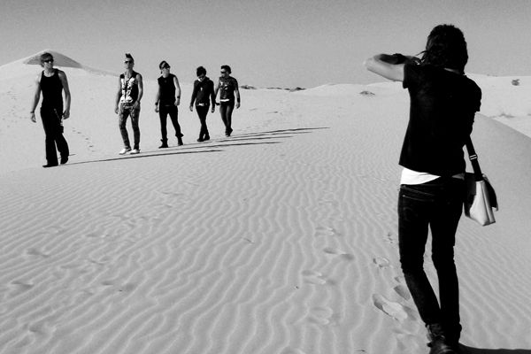 Behind the Scenes Band photoshoot Mark Maryanovich photographing My Darkest Days members as they walk in single file across sand dune black