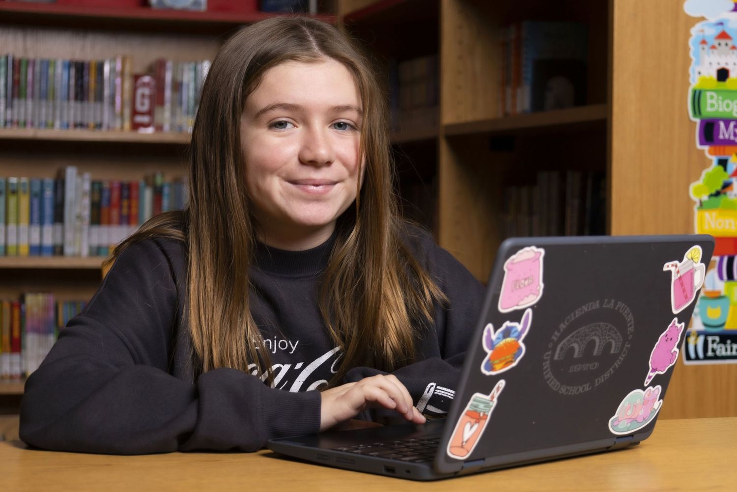 Microsoft Reading Coach  girl student sitting at desk in library with computer