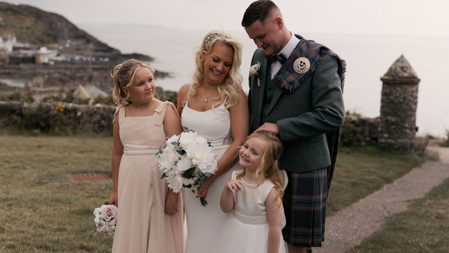 Bride and groom standing with their children at Portpatrick Hotel, Dumfries and Galloway