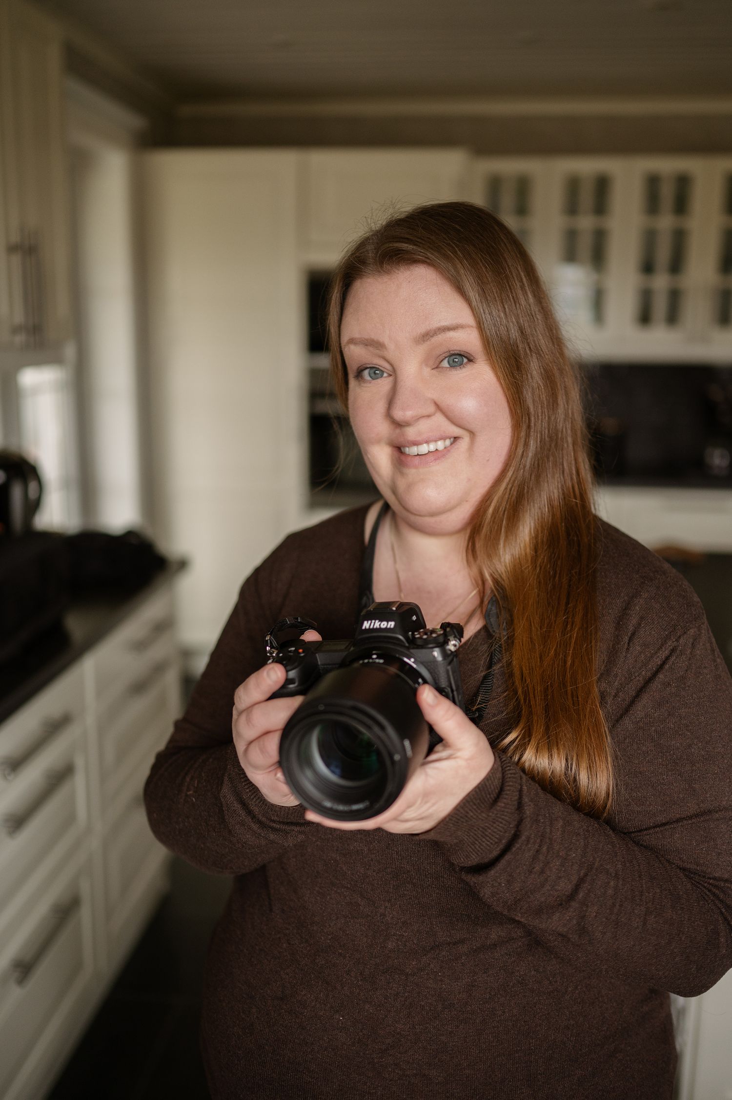 Porträtt av fotograf med kamera i händerna.