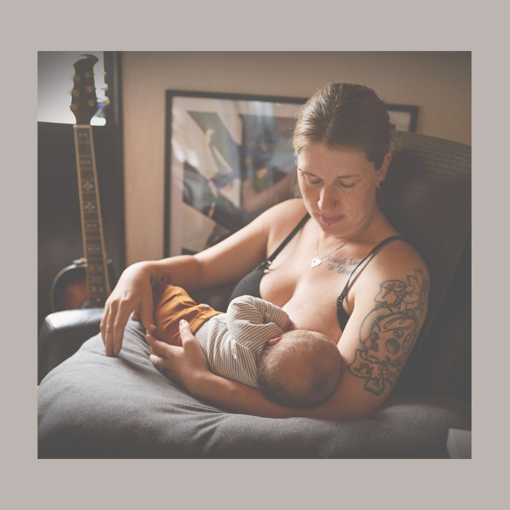 En mamma ammar sin bebis i en hemmamiljö, ett varmt och naturligt ögonblick. Fotograferat i Skaraborg.