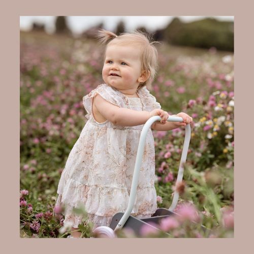Liten glad tjej på 1-årsfotografering bland blommande klöver. Fotograferat utanför Örslösa.