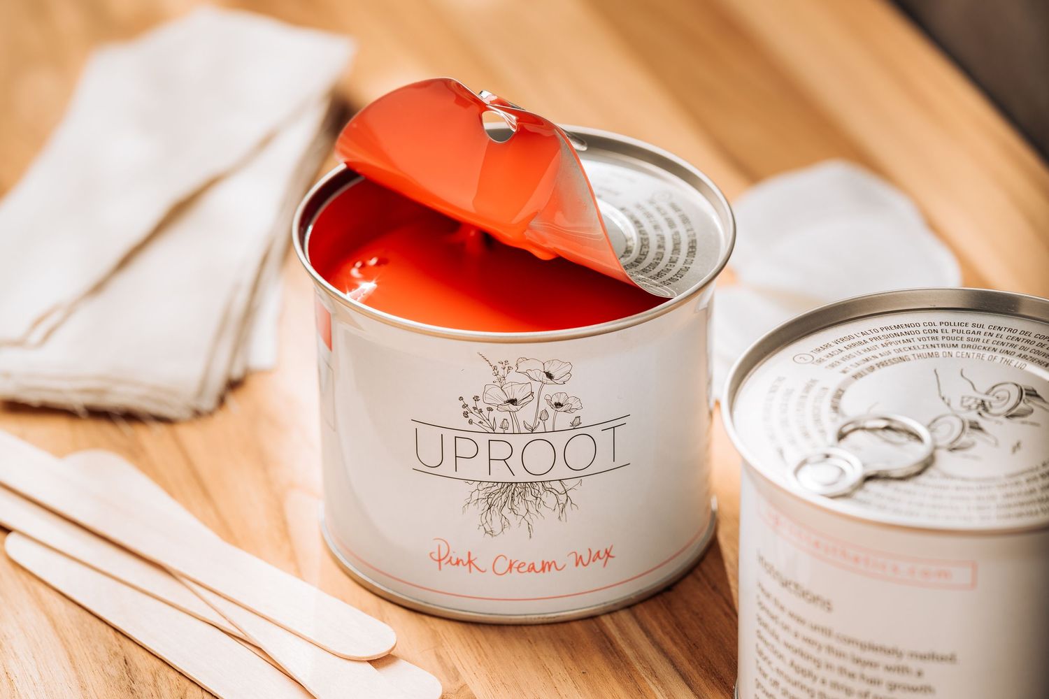 Red and silver tin jars and white sneakers arranged on wooden surface with warm lighting.