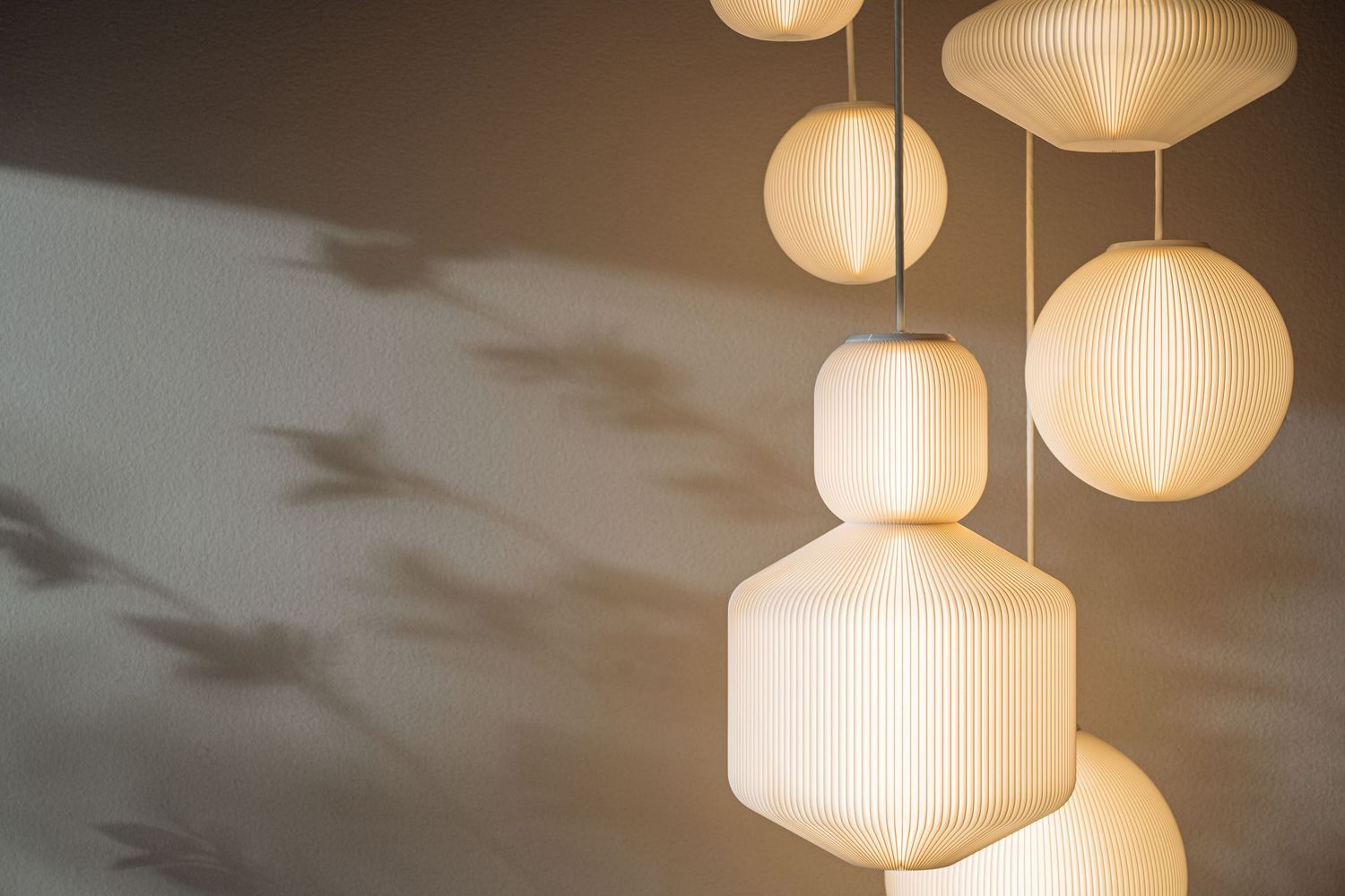 Modern pendant lights with white ribbed glass shades hanging from the ceiling create a warm, ambient glow.