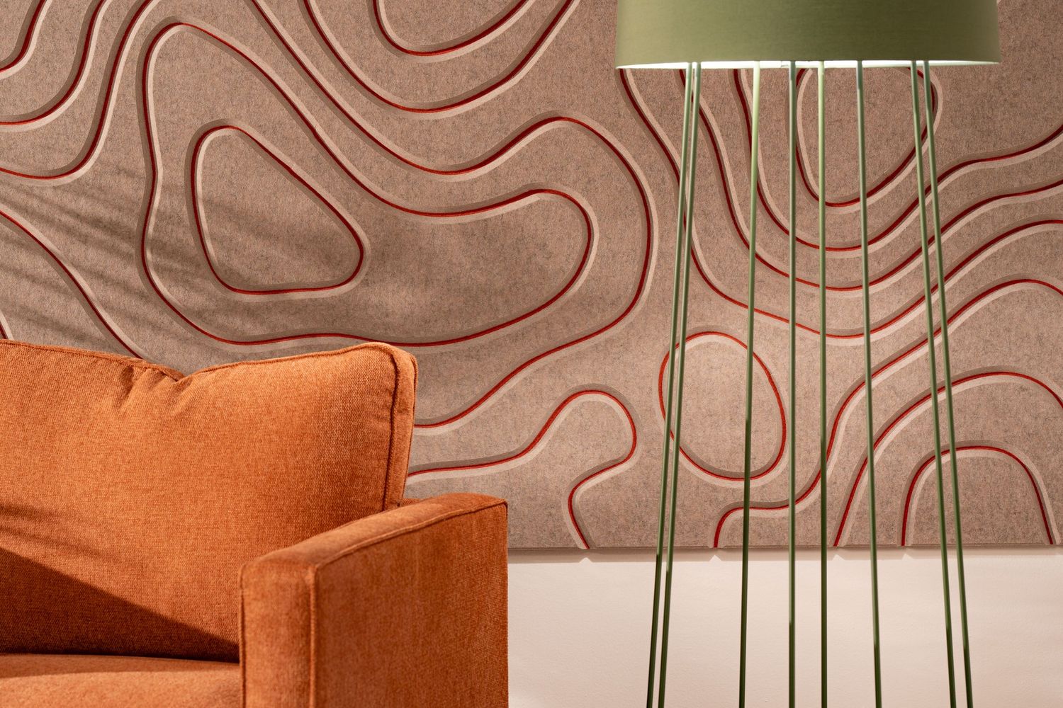 Modern living room detail with orange velvet armchair against textured brown wall pattern and contemporary floor lamp.