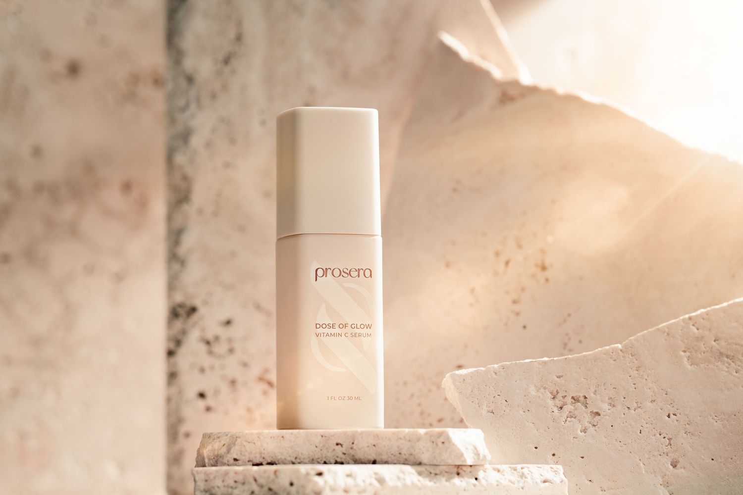 A bottle of skincare product on a white stone surface with soft, warm lighting and natural shadows.