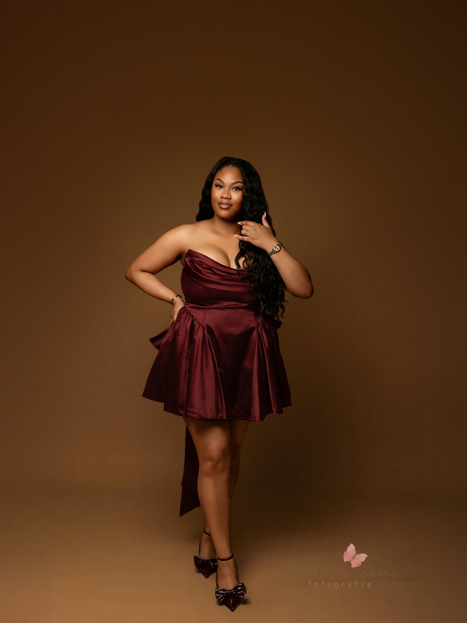 A woman in a burgundy dress poses gracefully against a brown backdrop in a series of elegant studio portraits.
