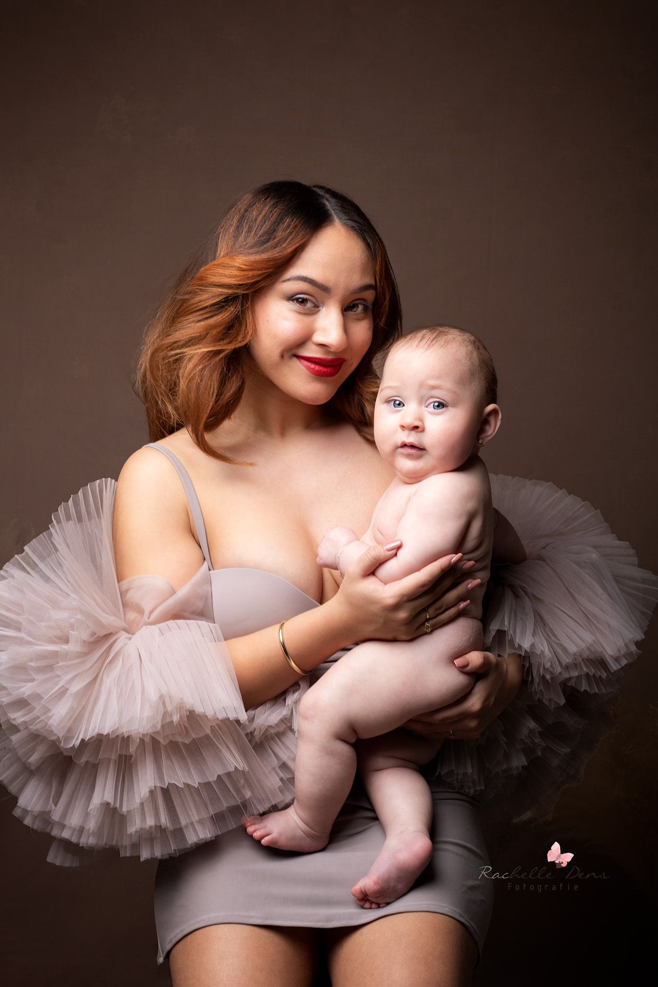 moeder met babydochter op schoot in een fotostudio