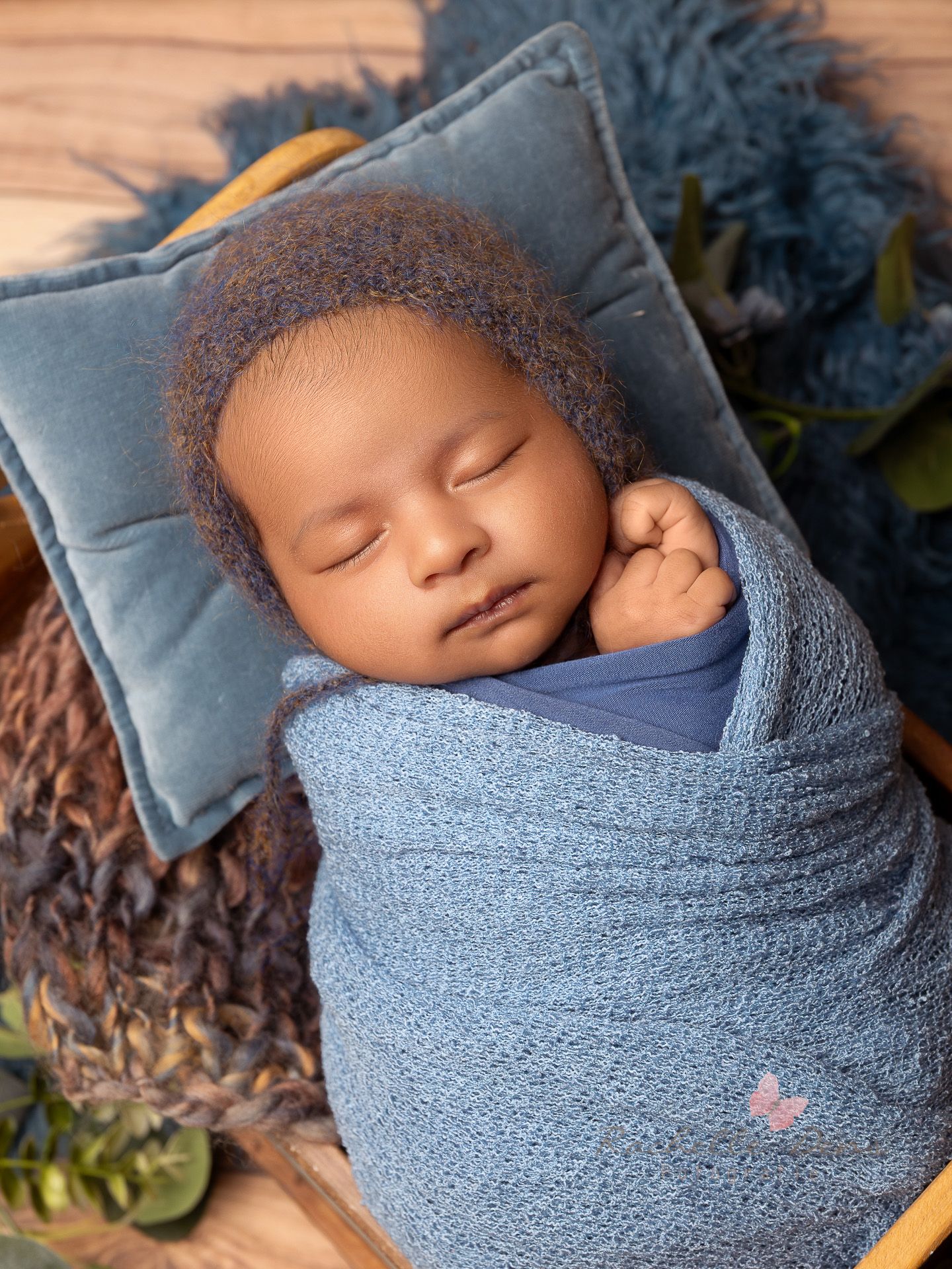 Sleeping newborn baby swaddled in soft blue fabric wrap photographed from different angles in a studio setting.