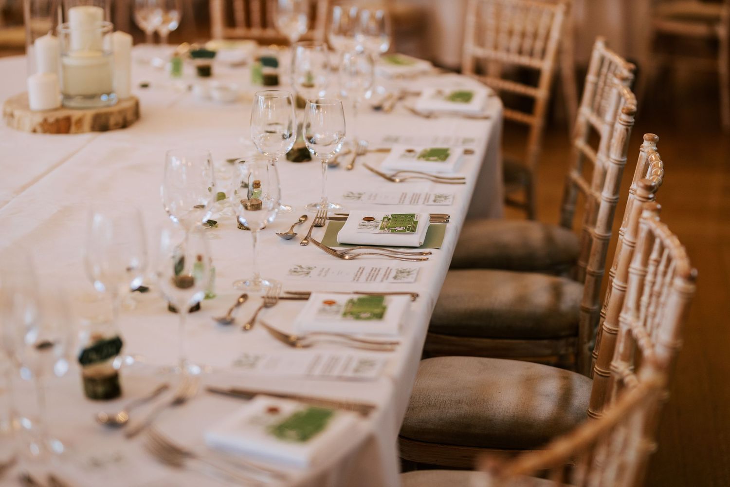 Elegant wedding reception table setting with white linens and place settings.