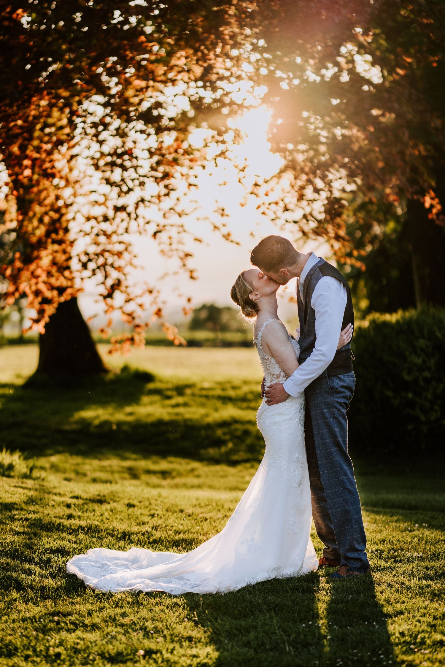 Romantic sunset portraits of newlyweds in a golden-lit meadow.