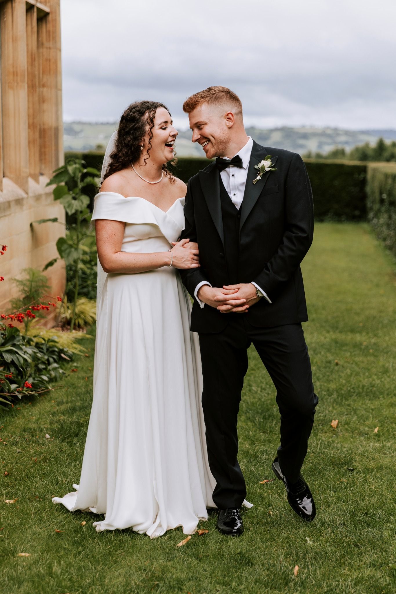 Intimate wedding portraits on manicured lawn with classical architecture backdrop.