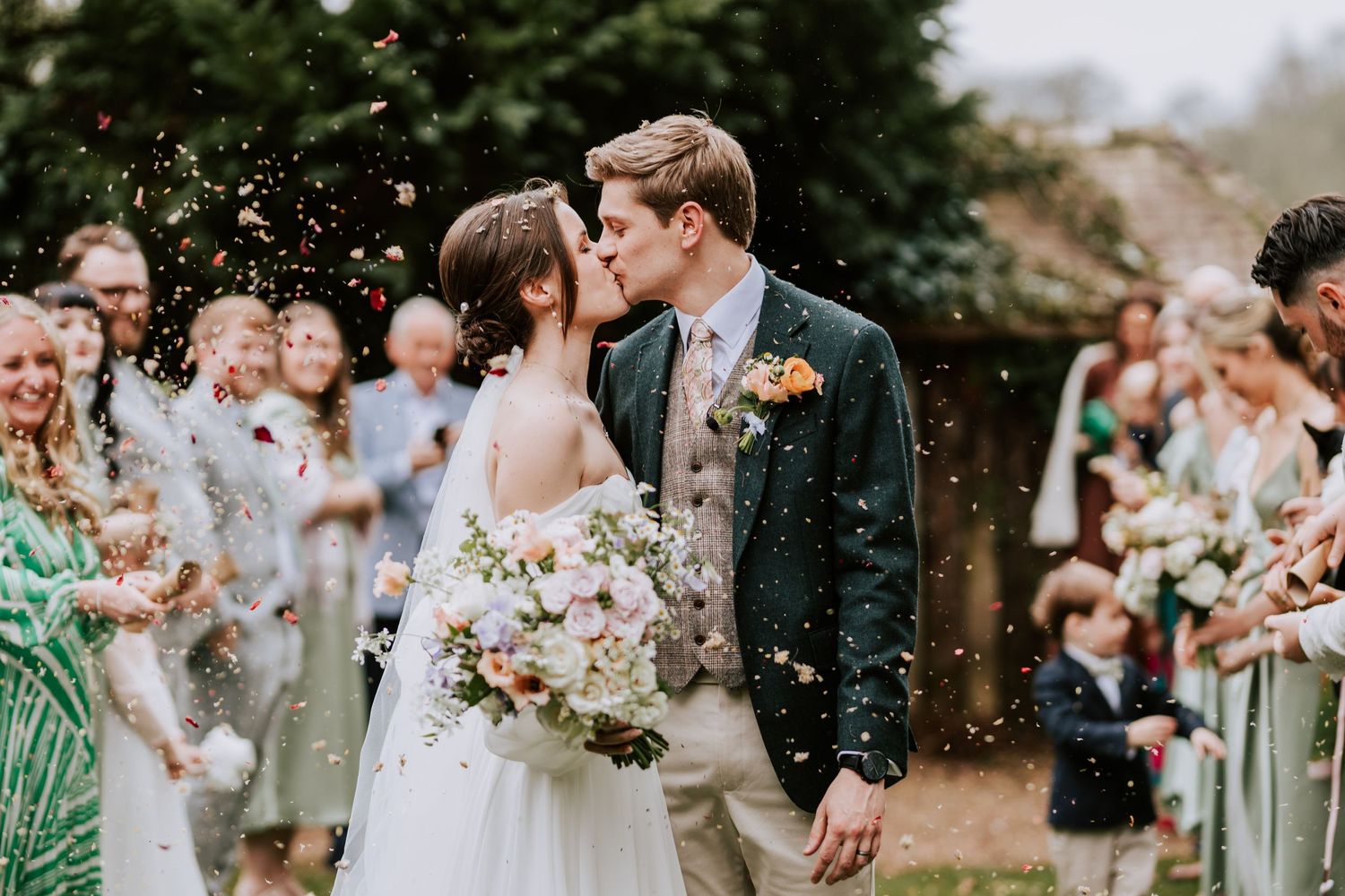 Wedding party celebrates with bridesmaids in sage green dresses during outdoor ceremony.