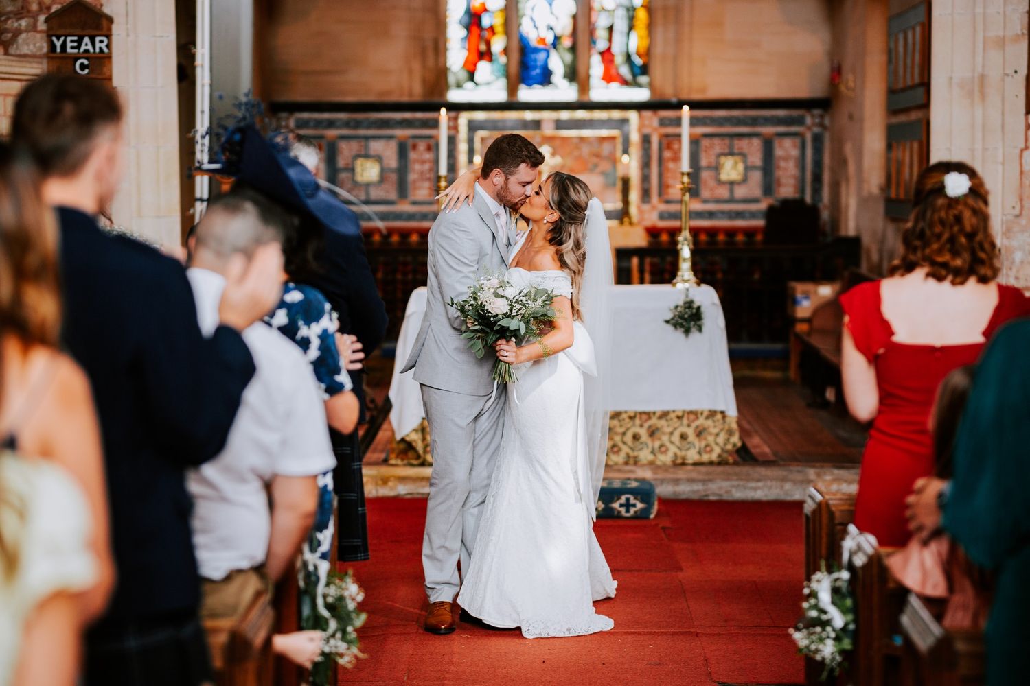 Wedding ceremony in historic church with stained glass windows and traditional decor.