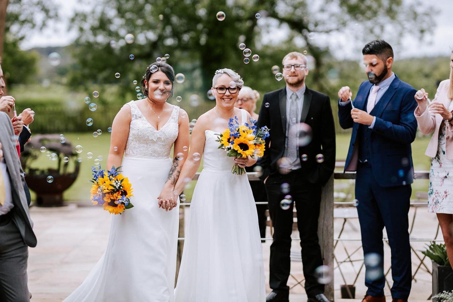 Wedding party celebrating with bubbles outdoors.