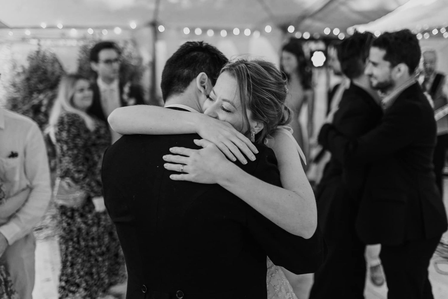 Black and white photo of an intimate embrace during a wedding dance.