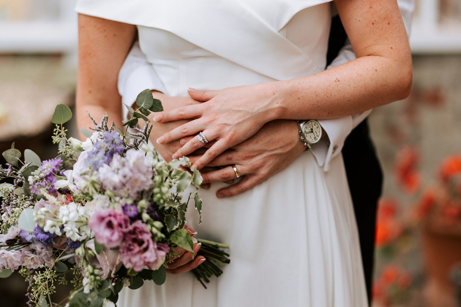 Close-up details of bridal bouquet with purple and pink flowers.