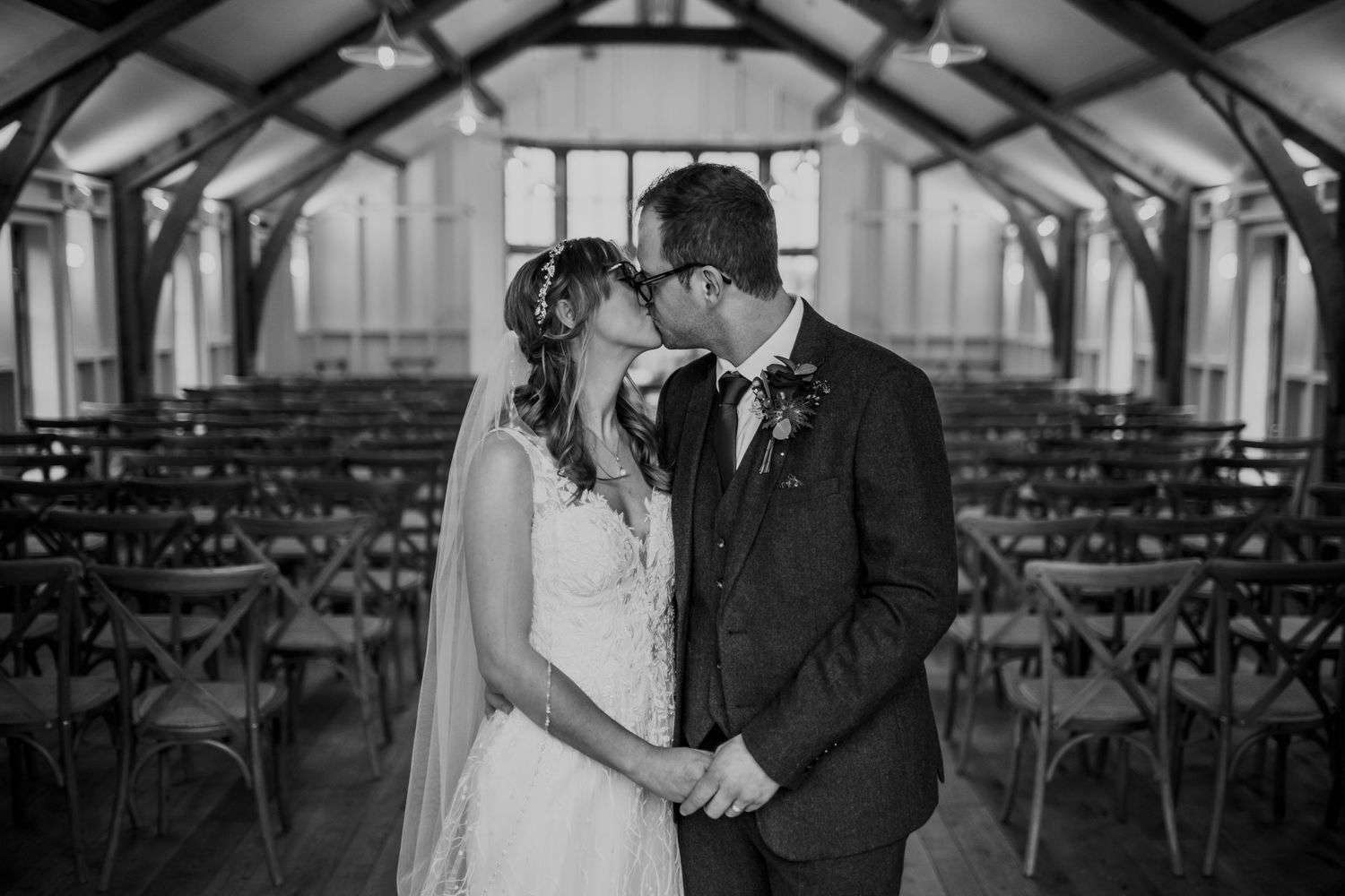 Wedding couple sharing an intimate moment during their indoor ceremony with elegant decor and lighting.