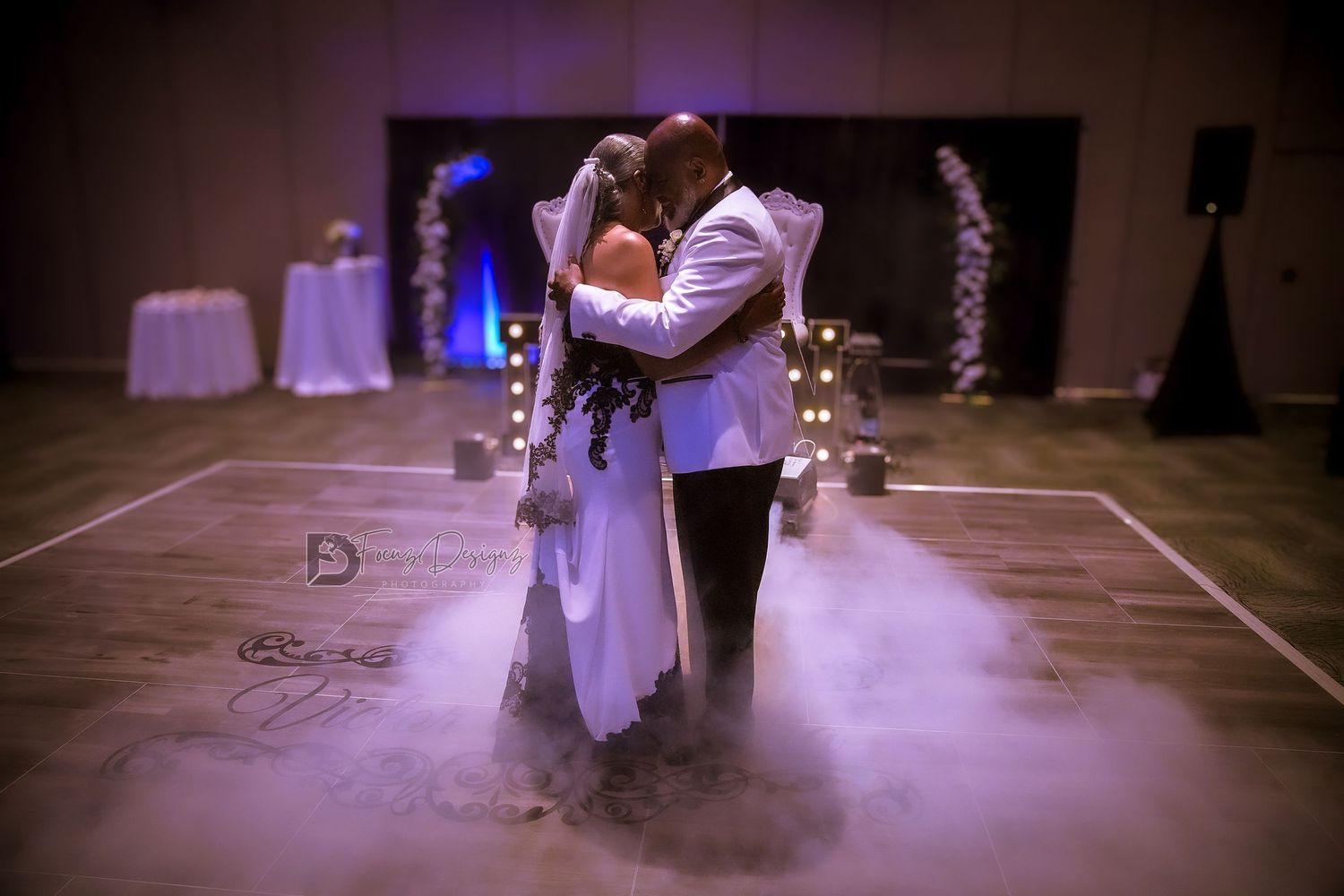 Romantic first dance with fog effects and string lights creating a dreamy atmosphere on the dance floor.