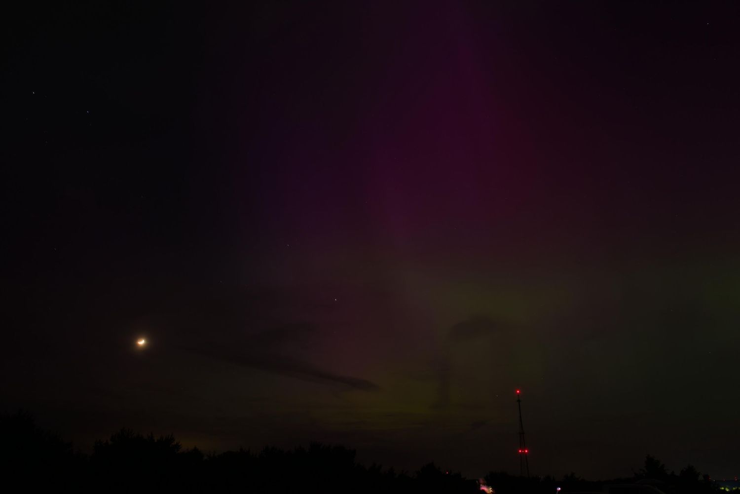 Blue, purple and green hues largely dominate behind a radio tower in Germantown, Ohio.