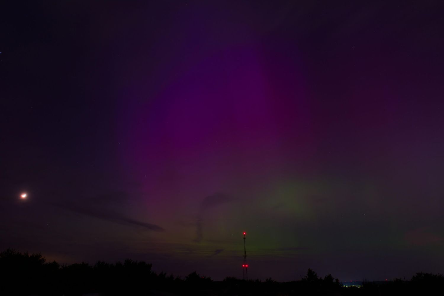 Blue, purple and green hues largely dominate behind a radio tower in Germantown, Ohio.