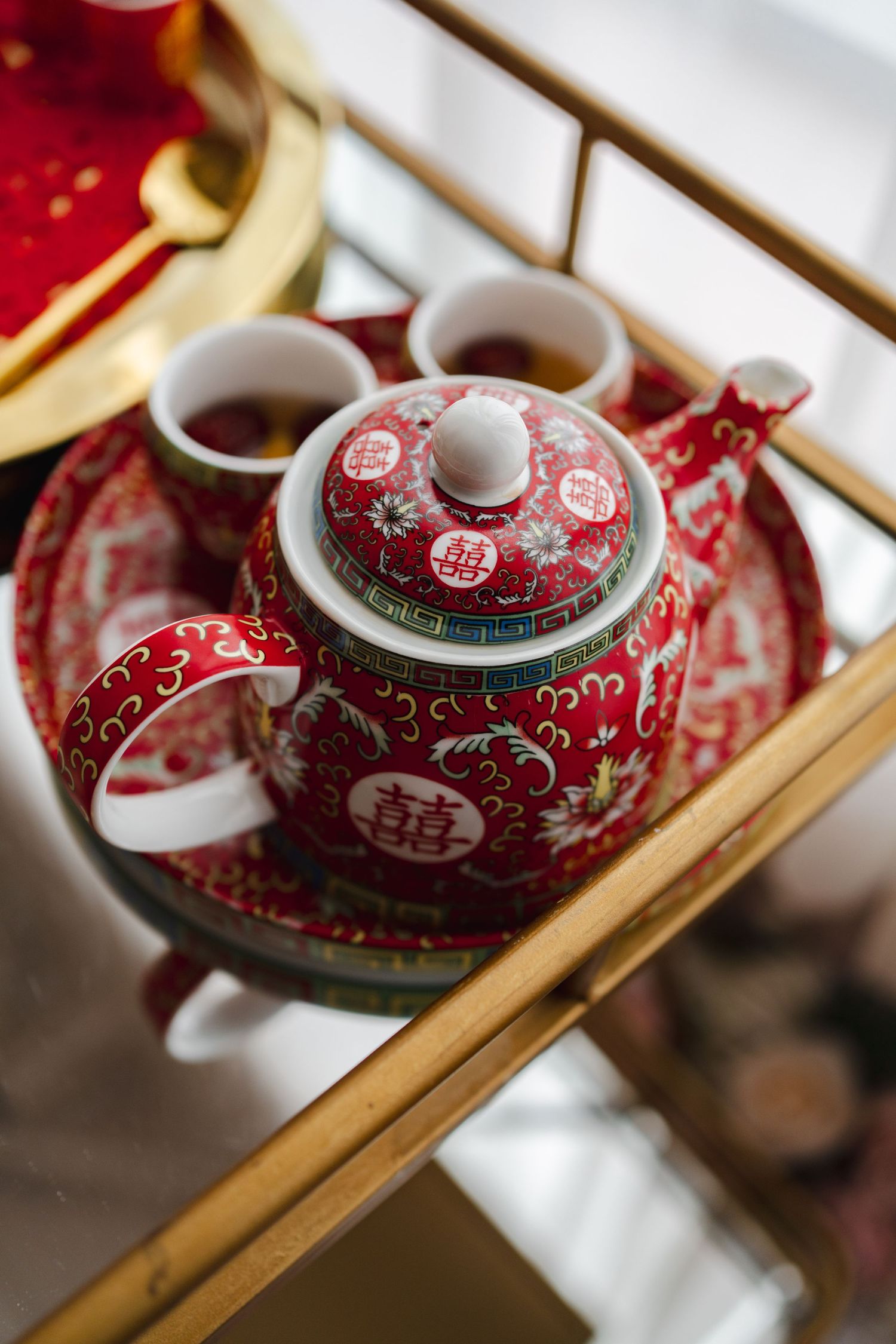 Traditional red Chinese wedding tea set with gold detailing displayed at ESpace Studios.