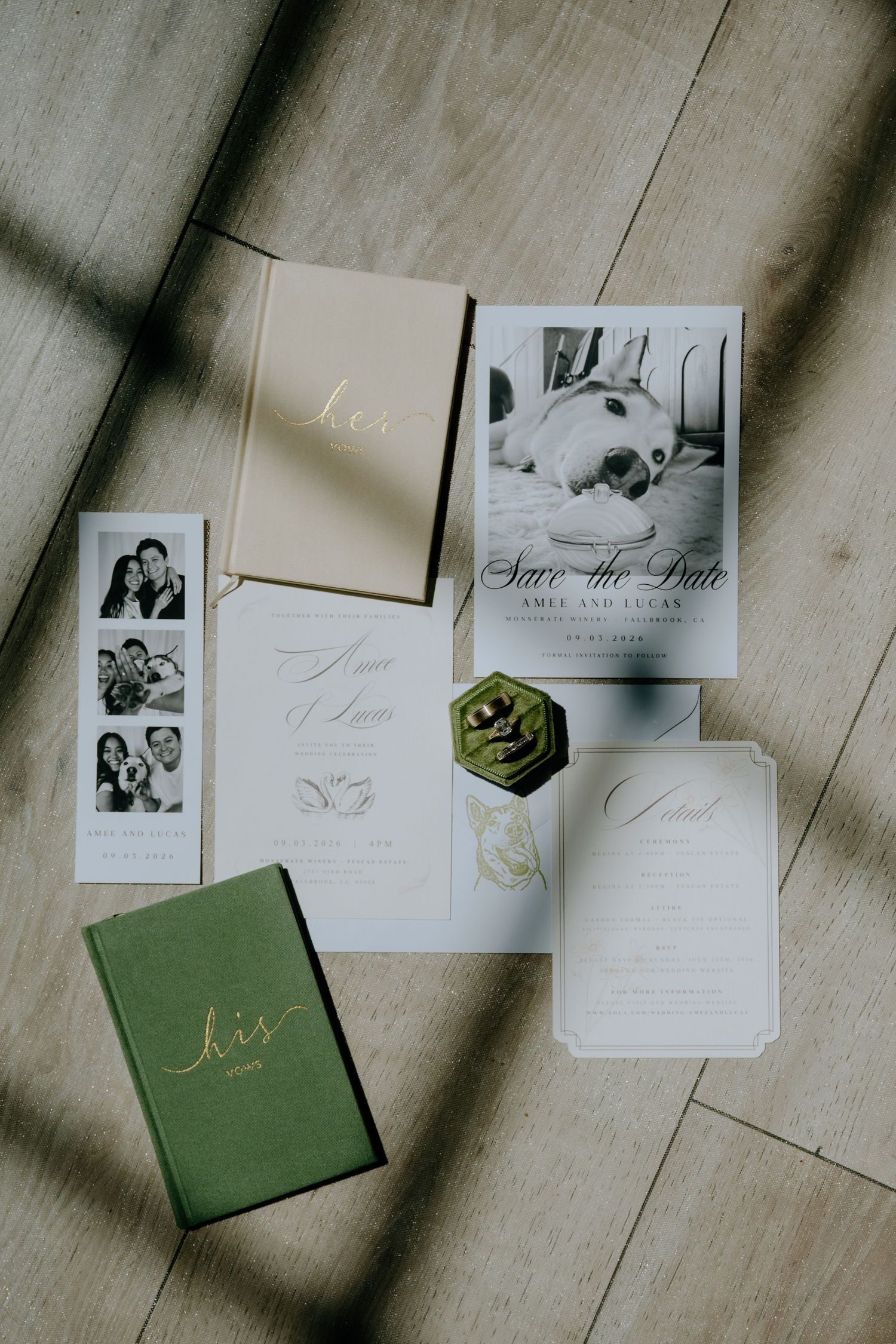 Elegant wedding stationery suite featuring save the date cards, vow books, and details card arranged on wood floor.