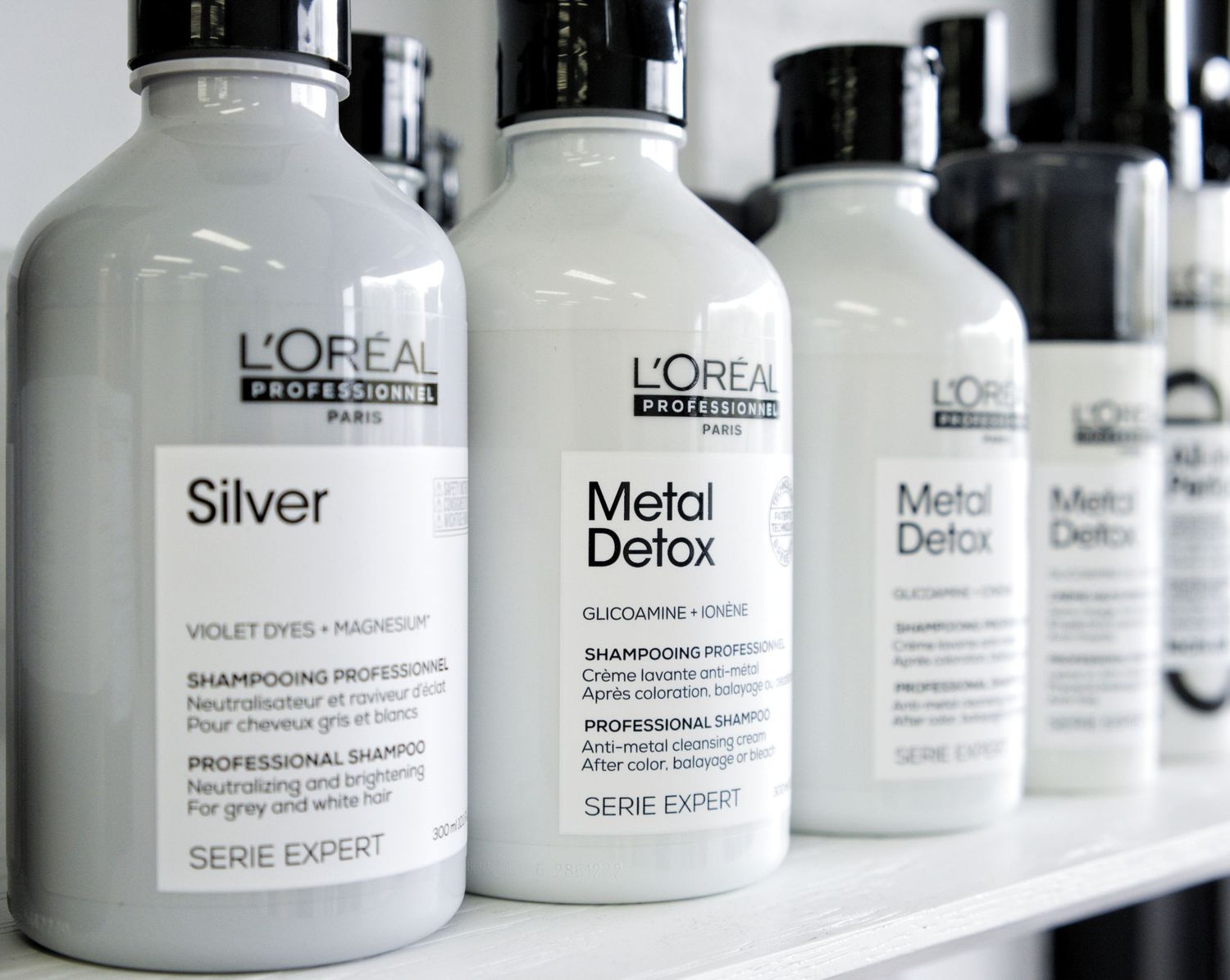 L'Oréal Professionnel Serie Expert Silver and Metal Detox shampoo bottles displayed on a white salon shelf.