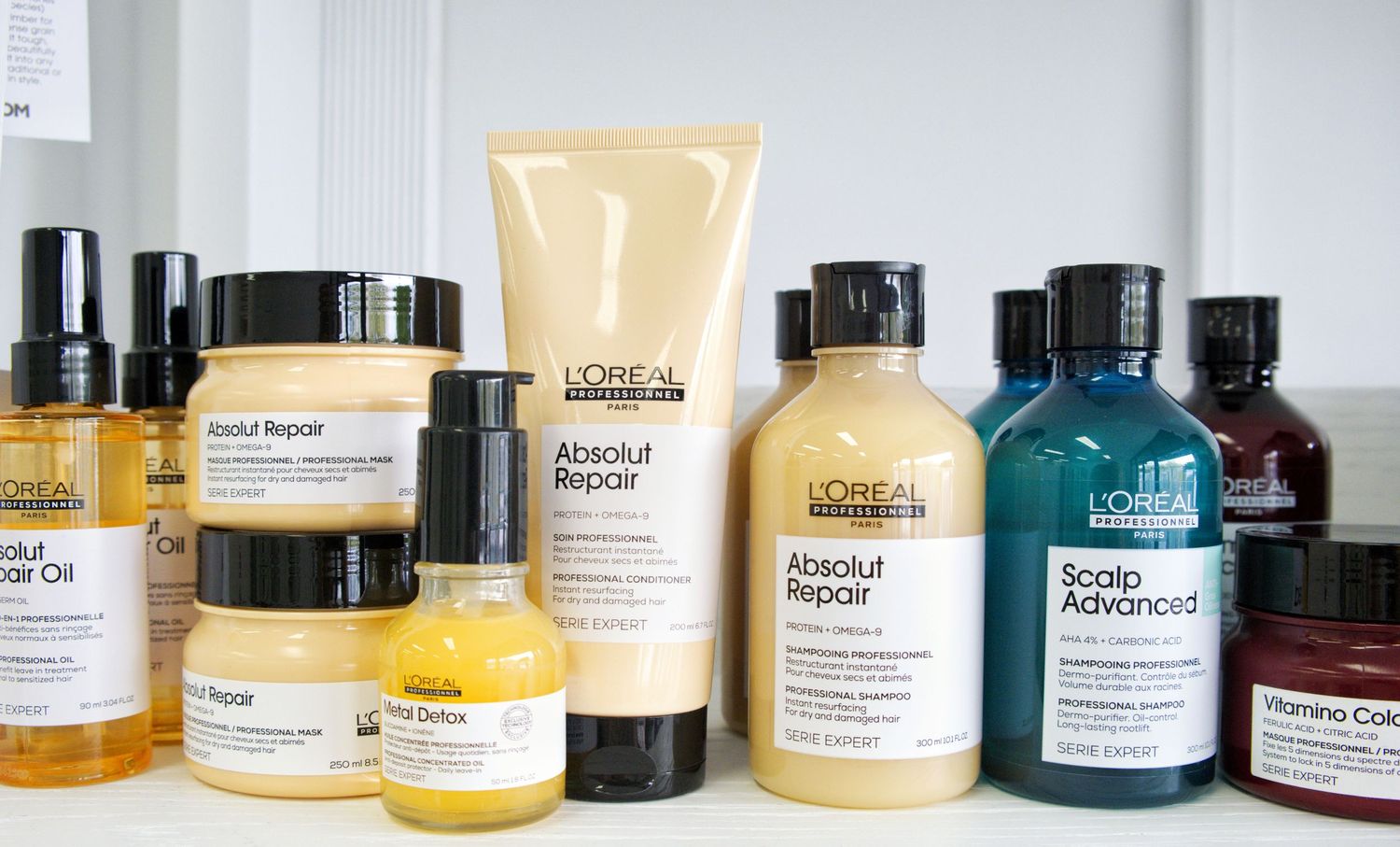 L'Oréal Serie Expert Absolut Repair, Scalp Advanced and Vitamino Color hair care products lined up on a salon shelf.