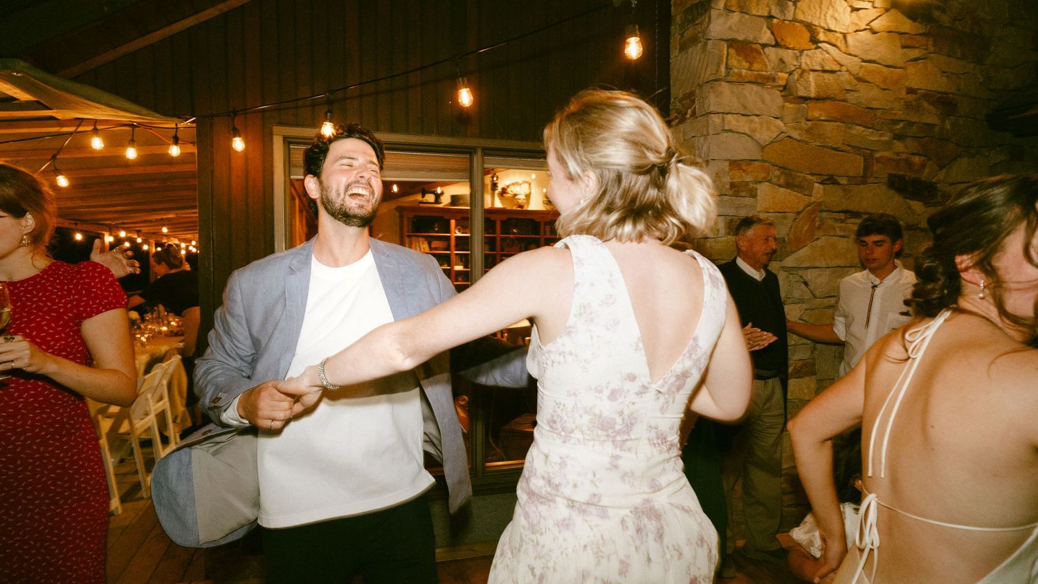 Couple dancing and smiling together at an elegant rustic wedding reception.
