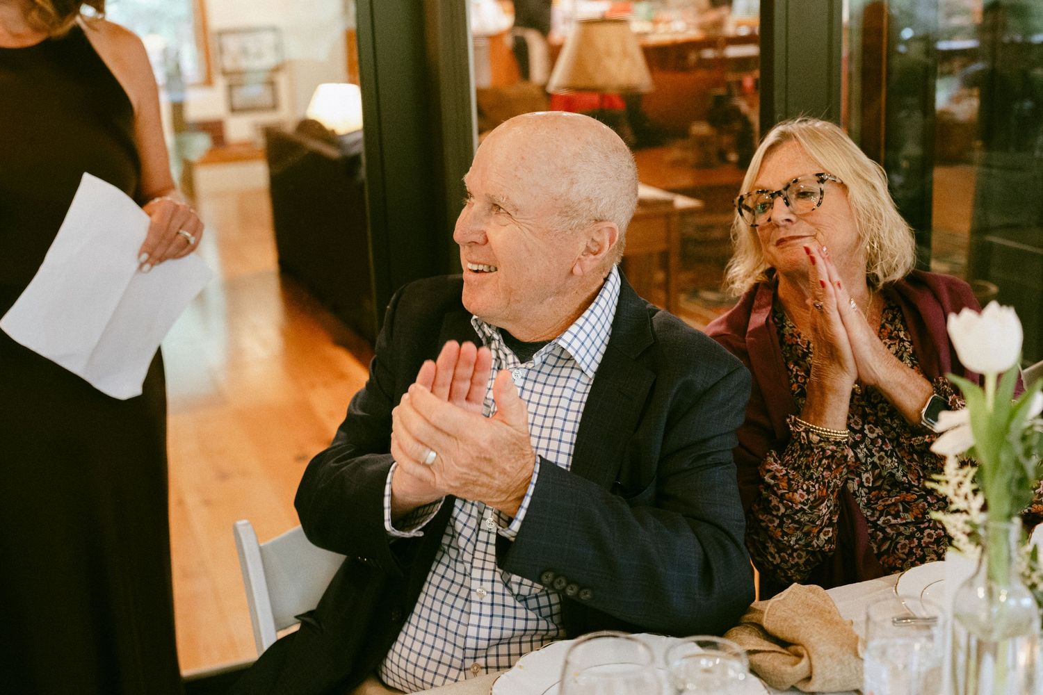 Guest clapping hands during a wedding reception speech.