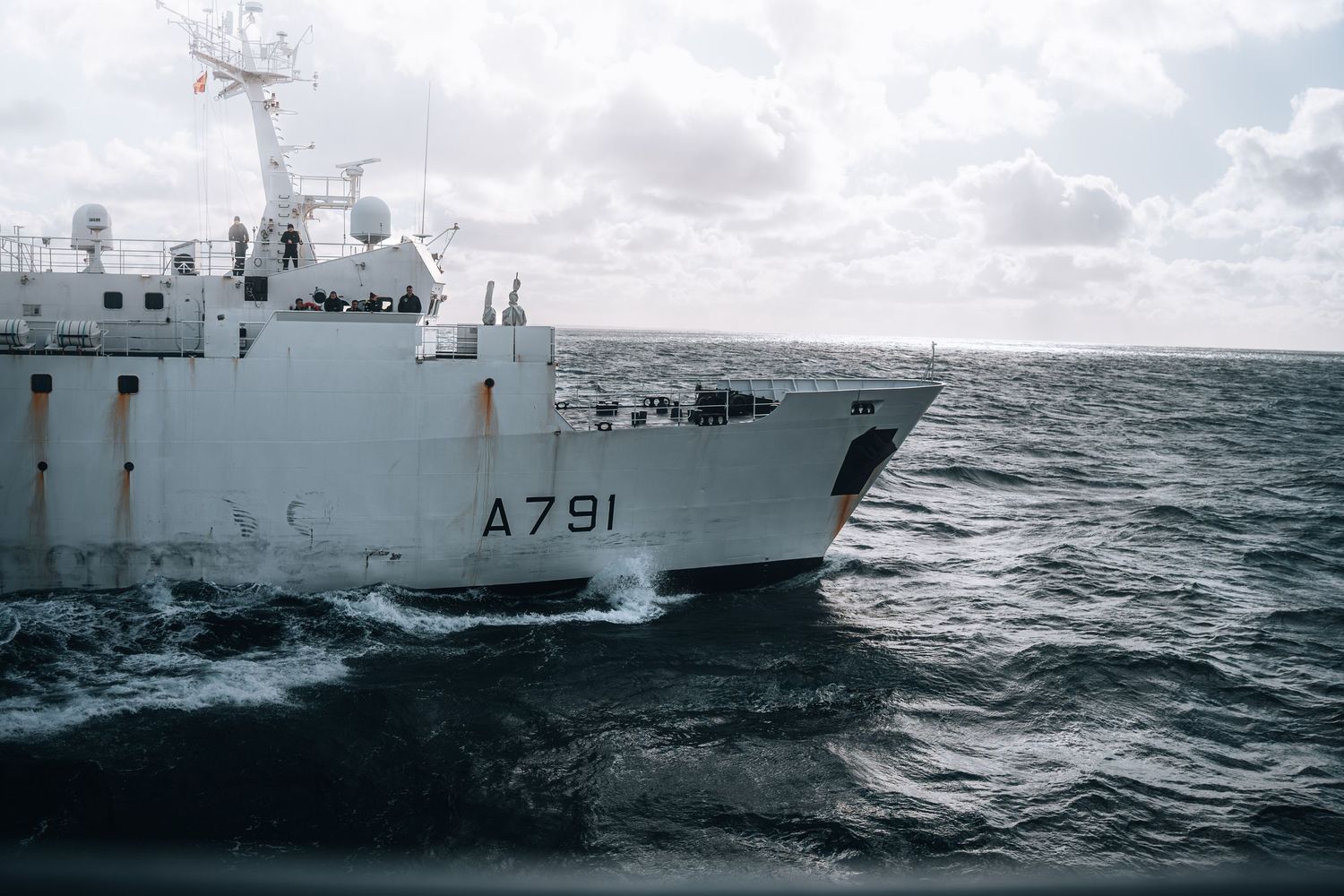 French naval support vessel A791 navigates rough open ocean waters under cloudy skies.