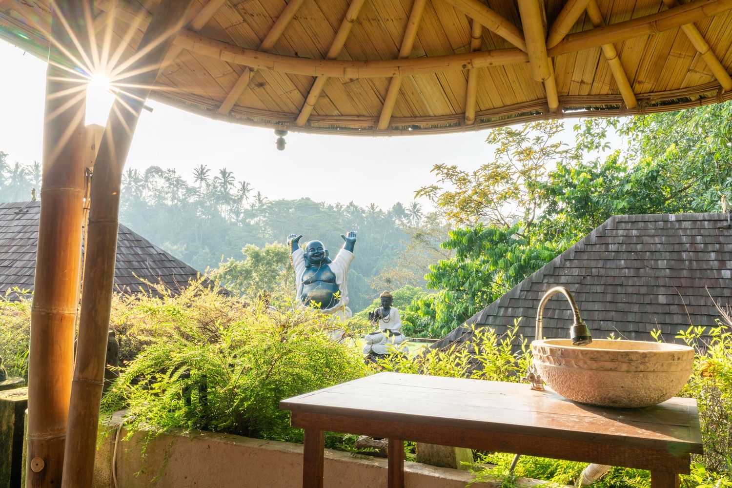 Smiling Buddha statue surrounded by natural textures.
