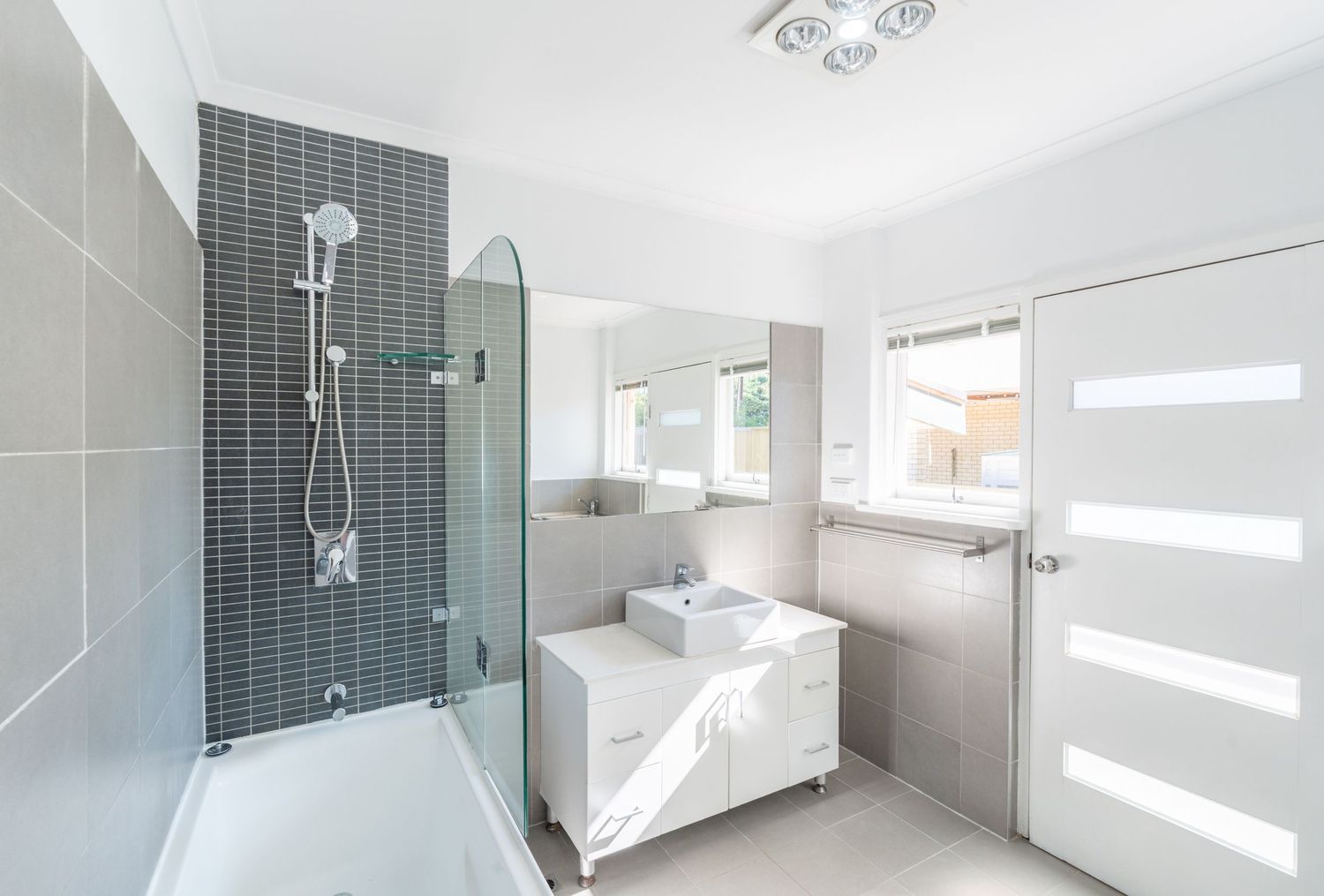 Bright modern bathroom with clean tiles and natural light.