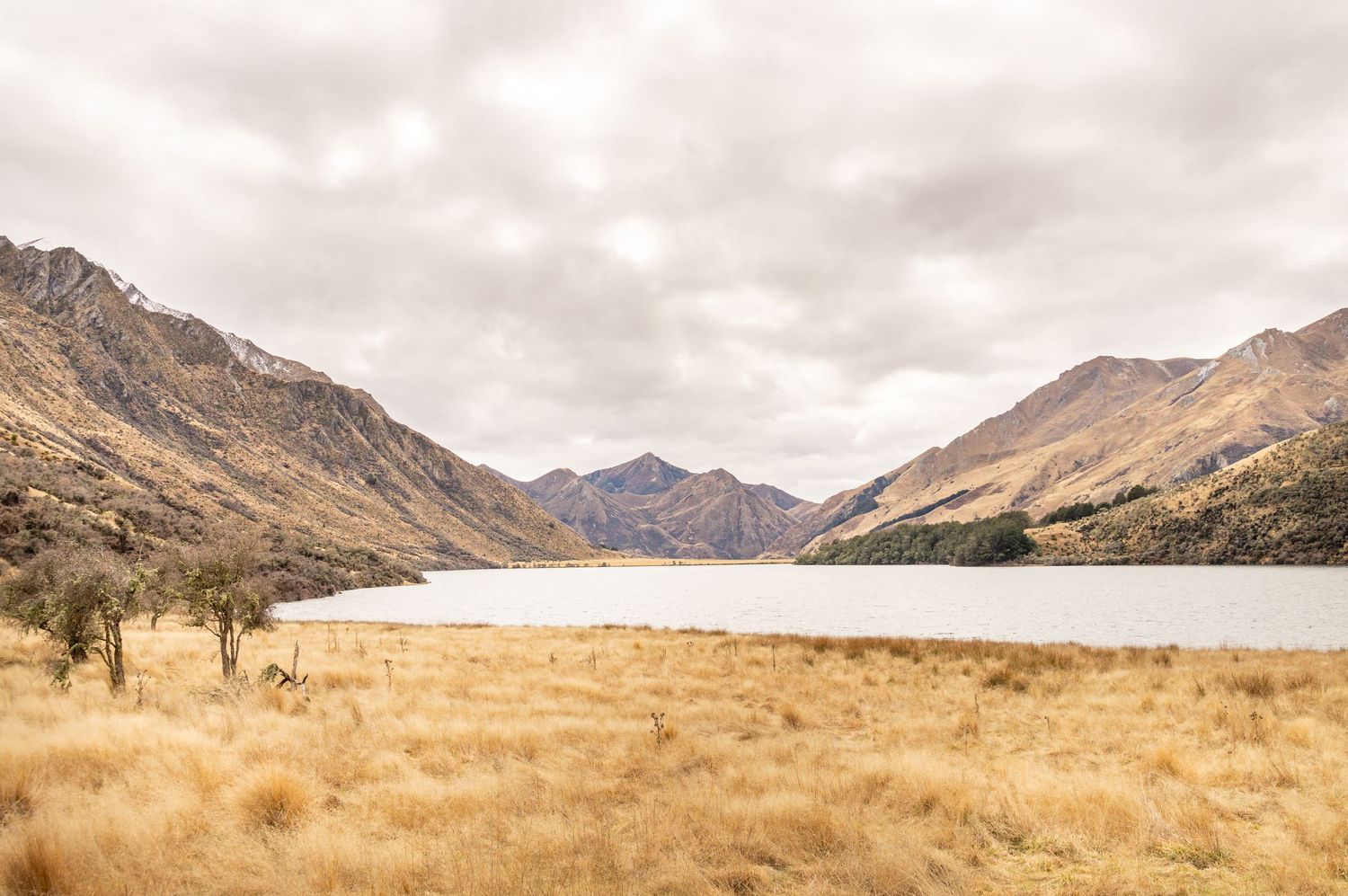 Moke Lake in New Zealand with still water and mountain backdrop.