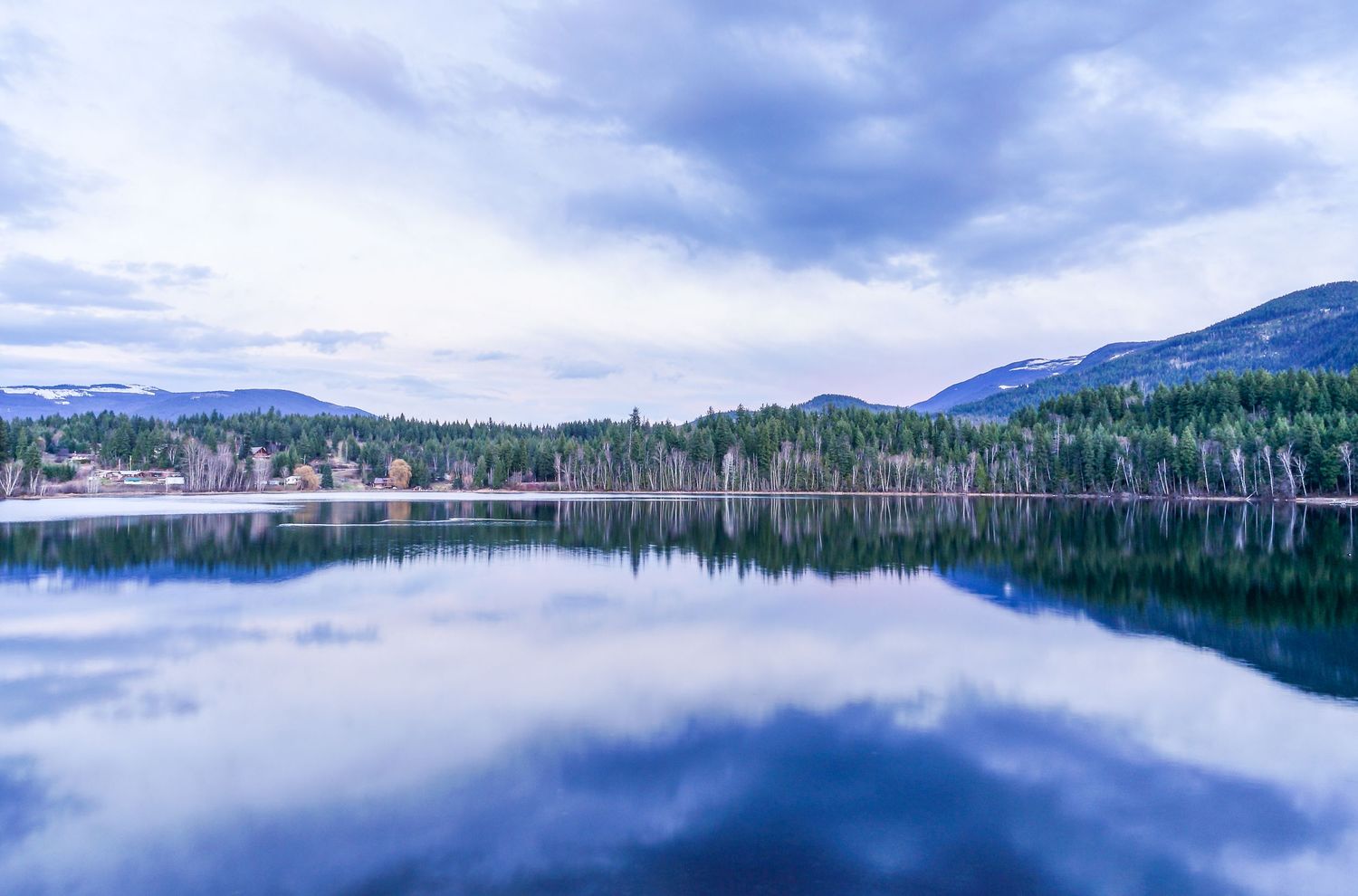 Clearwater lake landscape in Canada with reflections and mountains.