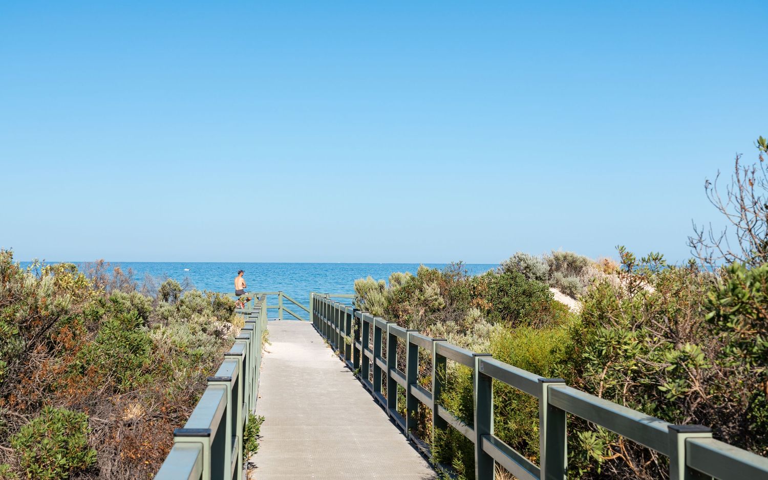 Coastal walking deck, path leading towards the beach.