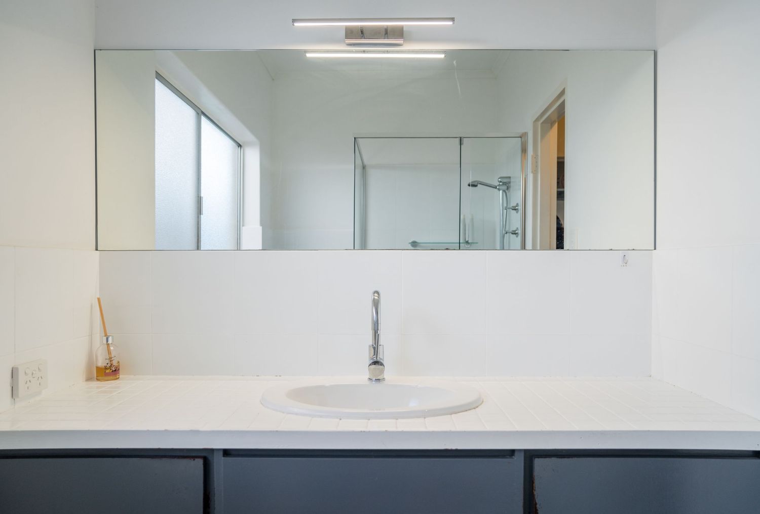 Bright modern bathroom with clean tiles and natural light.