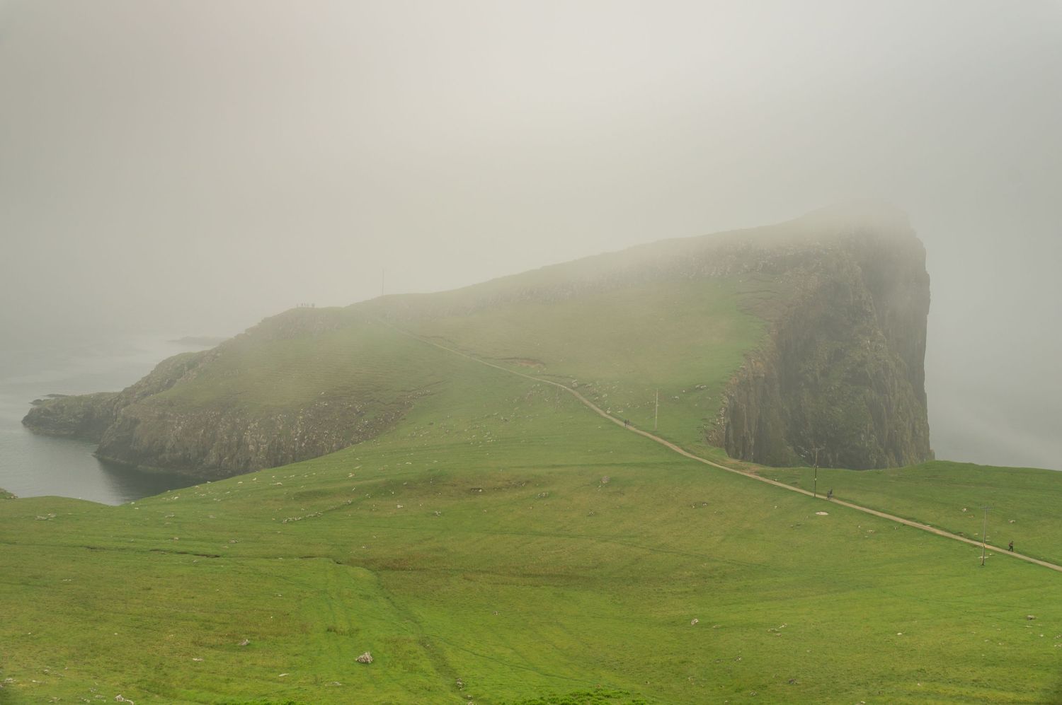 Lighthouse in foggy conditions with moody coastal atmosphere.
