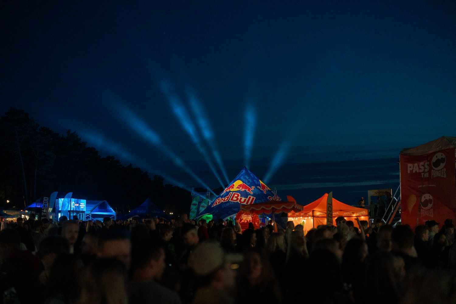 Festivali külastajad lava ees ja taamal Red Bull tell valgusvihkuses